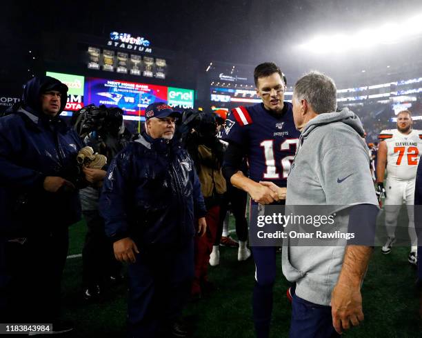 Tom Brady of the New England Patriots congratulates head coach Bill Belichick on his 300th win after the game against the Cleveland Browns at...