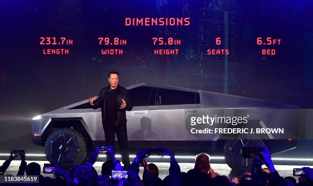 Tesla co-founder and CEO Elon Musk discusses vehicle dimensions in front of the newly unveiled all-electric battery-powered Tesla Cybertruck at Tesla...