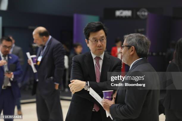 Kai-Fu Lee, chairman and chief executive officer of Sinovation Ventures, center, listens to Sanjay Mehrotra, president and chief executive officer of...