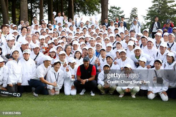 Tiger Woods of the United States poses for photographs with volunteers after winning the tournament after the final round of the Zozo Championship at...