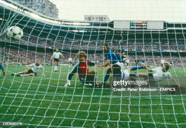 Italy's Paolo Rossi slides in to score the first goal despite the attentions of West Germany's Karl-Heinz Forster and goalkeeper Harald Schumacher ....