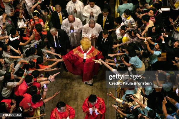 Pope Francis walks out from Assumption Cathedral as Thai youth reach out to touch him in Bangkok, Thailand on November 22, 2019. A embroidered...