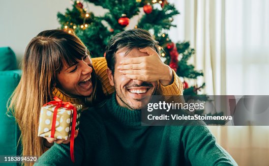 Romantic young couple exchanging Christmas gifts Romantic young couple exchanging Christmas gifts