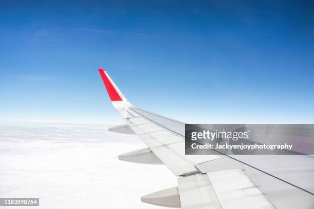 commercial plane flying over the arctic at sunset - airplane wing stockfoto's en -beelden