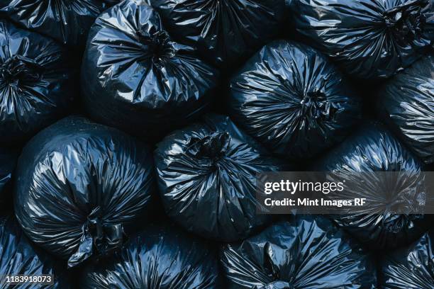 pile of black plastic garbage bags. - garbage stockfoto's en -beelden