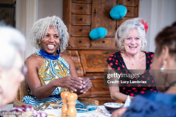 senior woman giving a speech and a present to her 65 year old friend for her birthday - 65 year old asian women stockfoto's en -beelden