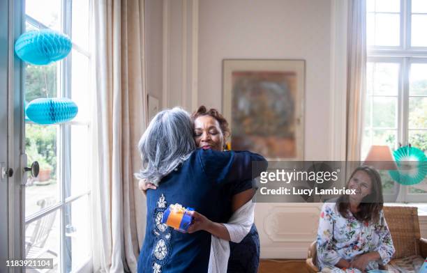 mature woman embracing her 65 year old friend for her birthday - 65 year old asian women ストックフォトと画像