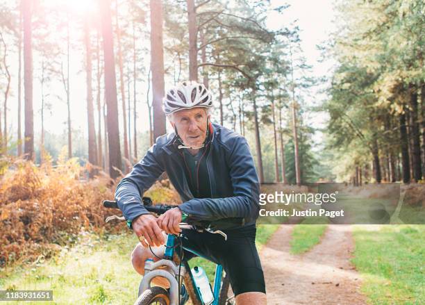senior male on bike in forest - active seniors biking stock pictures, royalty-free photos & images