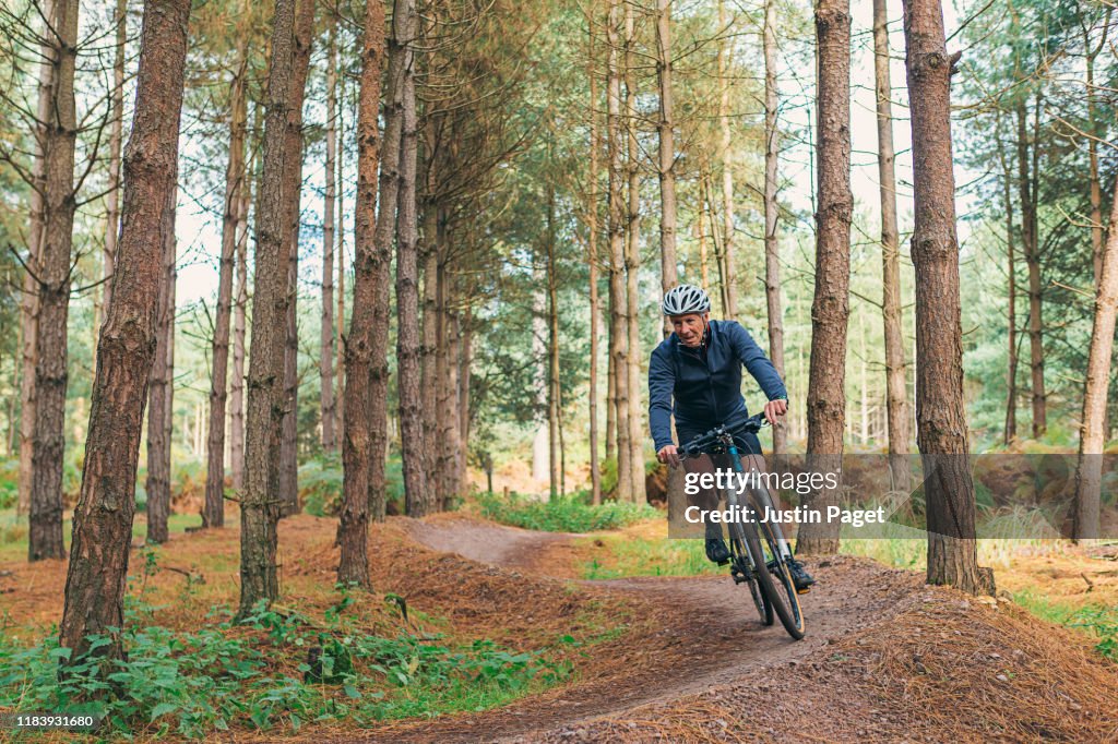 Senior male on bike trail in forest