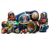 traditional Russian nesting dolls scattered in a mess on a white background