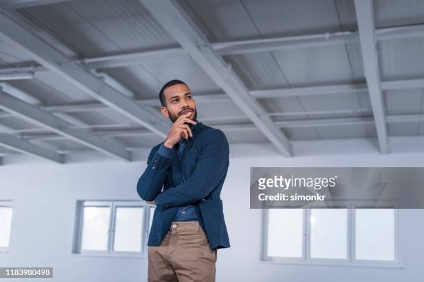 businessman standing in office - black blazer stock pictures, royalty-free photos & images