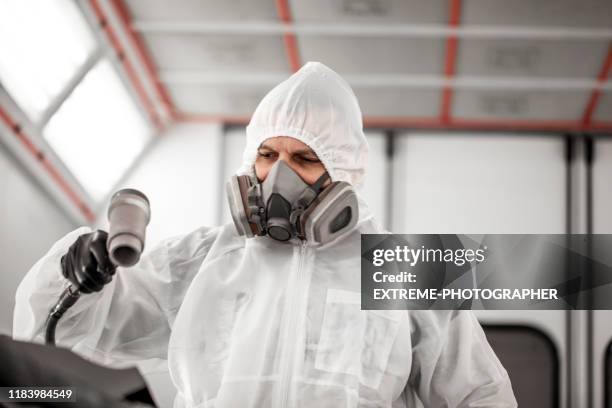 car painting technician using a pneumatic air dryer to quickly dry out paint coat on a car part in a car painting chamber in a body shop - spray booth stock pictures, royalty-free photos & images