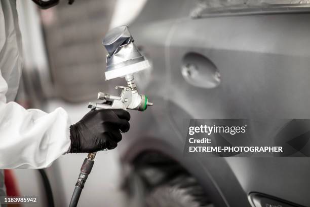 professional car painter blasting a car part with a base coat paint in a workshop - spray booth stock pictures, royalty-free photos & images