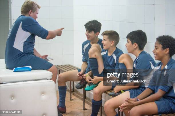 年輕的男足球運動員在更衣室玩得開心 - young boys changing in locker room 個照片及圖片檔