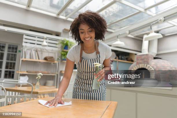 african american waitress cleaning the tables at a restaurant - restaurant cleaning stock pictures, royalty-free photos & images