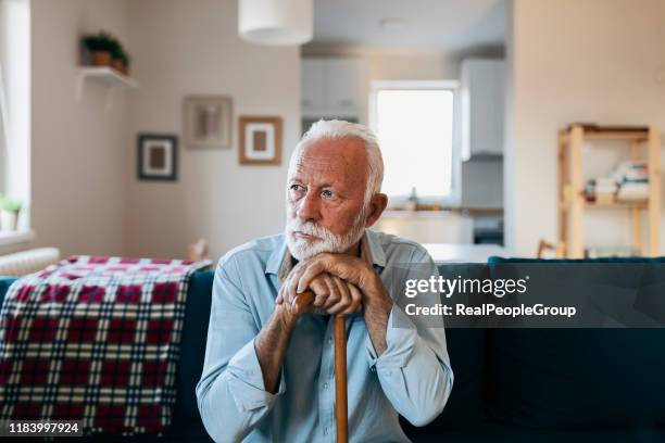 älterer mann sitzt allein zu hause - sad old man stock-fotos und bilder