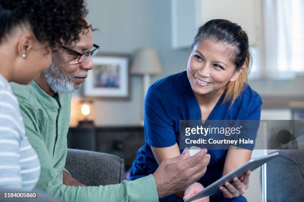 home healthcare nurse with senior man and his adult daughter - explaining stock pictures, royalty-free photos & images