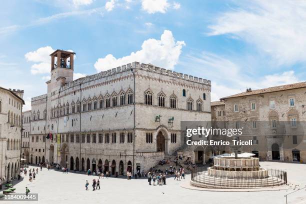 photograph of the main square of perugia (piazza 4 novembre), with a view of the fontana maggiore and the town hall. in the background blue sky and clouds. - perugia fotografías e imágenes de stock