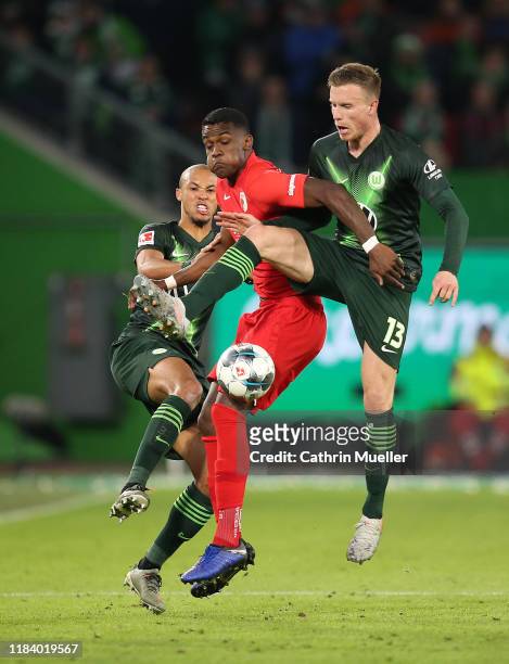 Marcel Tisserand and Yannick Gerhardt of VfL Wolfsburg and Sergio Cordova of FC Augsburg battle for the ball during the Bundesliga match between VfL...
