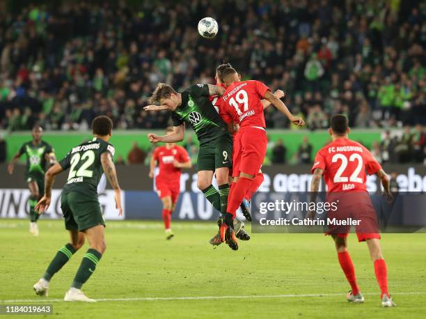 Wout Weghorst of VfL Wolfsburg and Felix Uduokhai of FC Augsburg battle for the ball during the Bundesliga match between VfL Wolfsburg and FC...