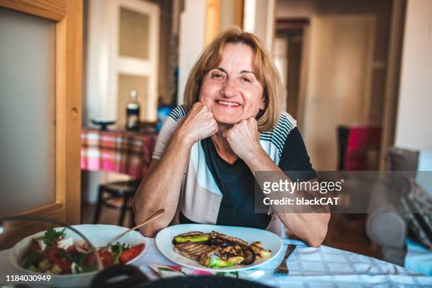 portrait of senior woman eating lunch - slavic culture stock pictures, royalty-free photos & images