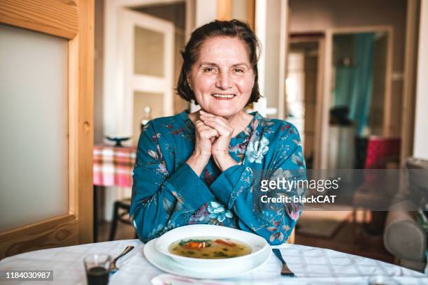 porträt der seniorin am küchentisch - slawische kultur stock-fotos und bilder