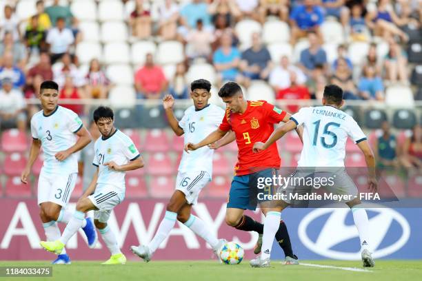 Jordi Escobar of Spain dribbles between Ignacio Fernandez and Cristian Medina of Argentina during the FIFA U-17 World Cup Brazil 2019 group E match...