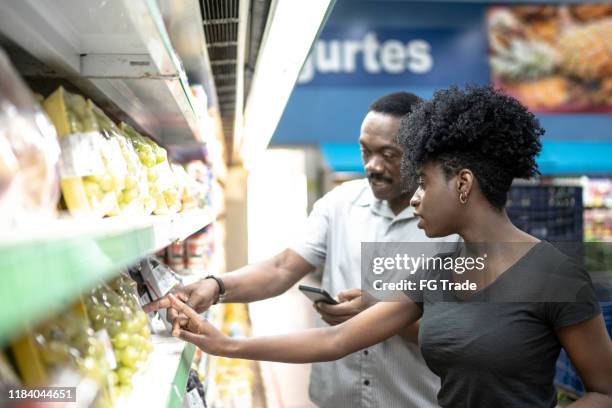 happy father and daughter in supermarket - phone comparison stock pictures, royalty-free photos & images