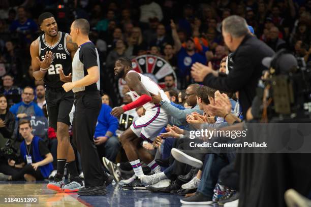 Rudy Gay of the San Antonio Spurs reacts as James Ennis III of the Philadelphia 76ers is picked up after making a three-point shot during a game at...