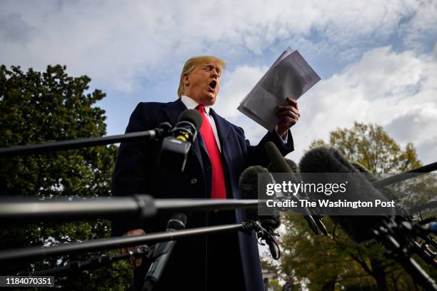 President Donald J. Trump reads his notes as he speaks to reporters before boarding Marine One as he departs from the South Lawn at the White House...