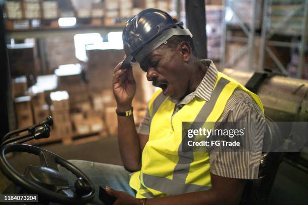 tired african mature forklift driver man - frustrated workman stock pictures, royalty-free photos & images