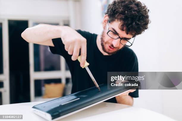 young man repairing laptop - damaged laptop stock pictures, royalty-free photos & images