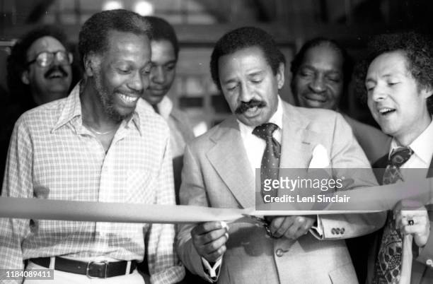 Congressman John Conyers cutting the ribbon at the opening of the Detroit Jazz Center, with politician Jack Faxon and author/historian Herb Boyd and...
