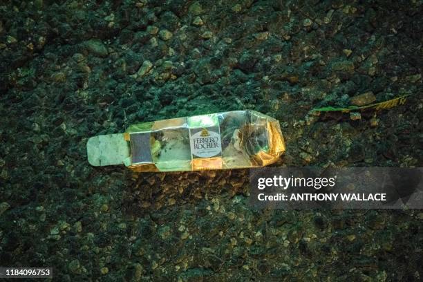 In this picture taken on November 18 an empty packet of Ferrero Rocher chocolates is seen on a road outside the main entrance of the Hong Kong...