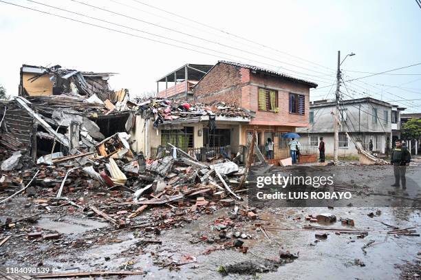Policeman stands beside the rubble of a house at the scene of a blast targeting a police station in Santander de Quilichao, Cauca department, on...