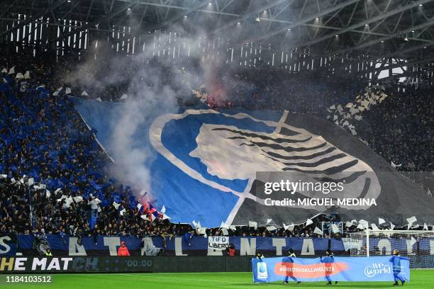 Fans unfurl a huge tifo as children hold a banner reading "A Red Card to Violence" and "WeWorld Onlus with children, with women, for their rights"...