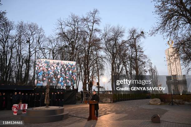 Ukrainian President Volodymyr Zelensky addresses to audience during a commemoration ceremony at a monument of victims of the Holodomor famine of...