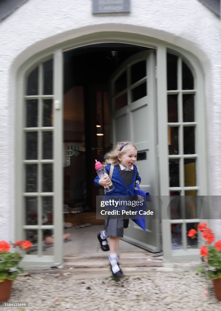 Young girl leaving house to go to school