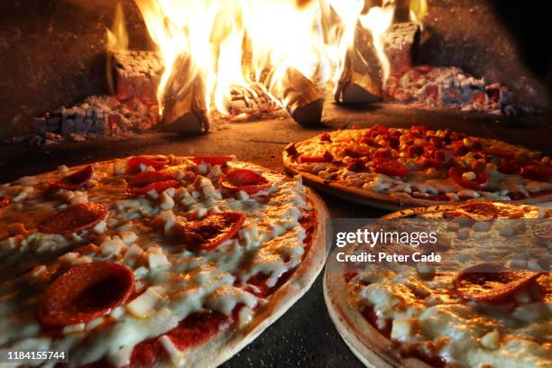 pizzas in pizza oven - pizza fotografías e imágenes de stock