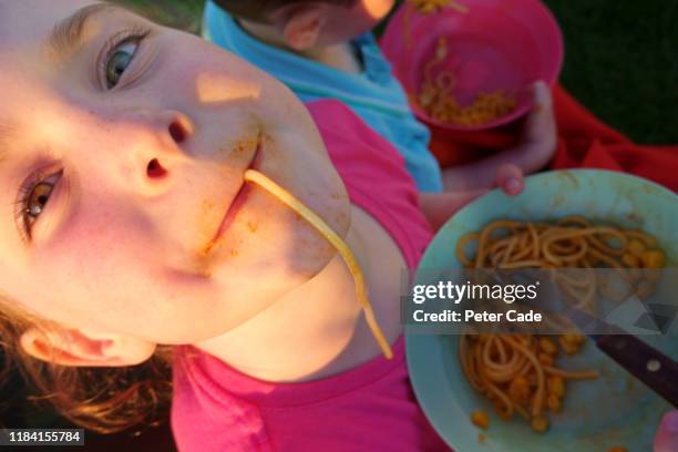 children eating spaghetti outside - spagetti stock pictures, royalty-free photos & images