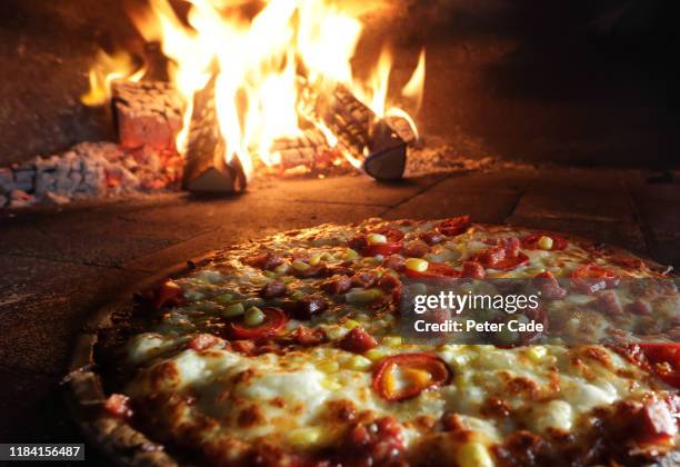 pizzas in pizza oven - pizzeria stockfoto's en -beelden
