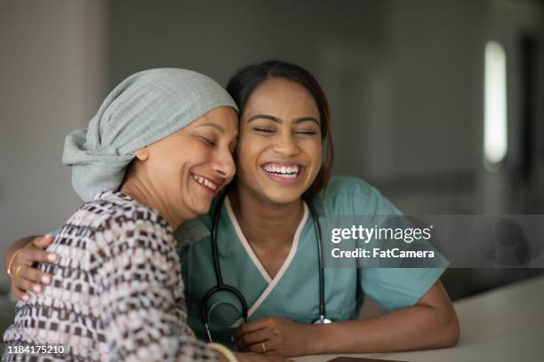 senior oncologie patiënt deelt een lach met haar vrouwelijke arts stock photo - arabic doctor stockfoto's en -beelden