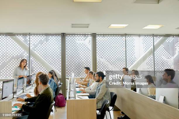 teacher teaching students in computer lab - computer lab stock pictures, royalty-free photos & images