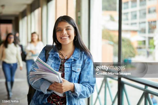 smiling woman standing in corridor at university - latin american and hispanic ethnicity student stock pictures, royalty-free photos & images