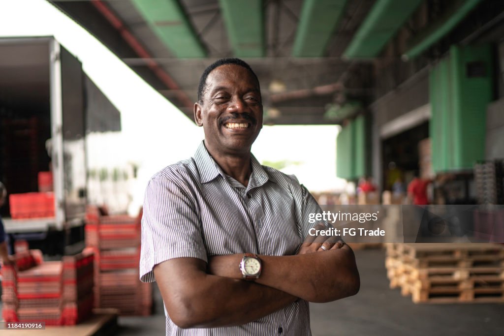 African mature man owner portrait at warehouse