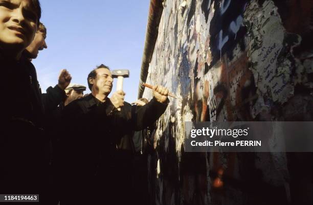 Des jeunes percent un trou dans le Mur de Berlin après sa chute, le 12 novembre 1989, Allemagne.