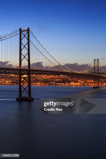 lisbon - ponte 25 de abril at sunset (bridge of april 25) - portugal - 25 de abril bridge stockfoto's en -beelden