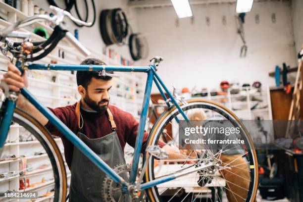 proprietario di un negozio di biciclette che lavora su biciclette d'epoca - piccola impresa foto e immagini stock