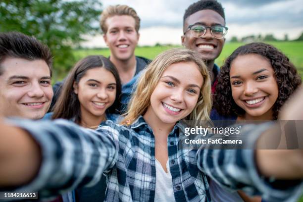 multi_ethnic tieners het nemen van een zelfportret stockfoto - een groep mensen stockfoto's en -beelden