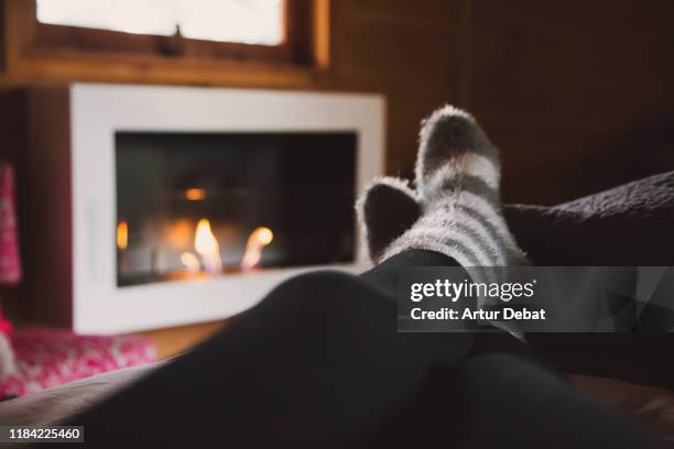 woman with comfortable socks at home with chimney. - socks fireplace stock pictures, royalty-free photos & images